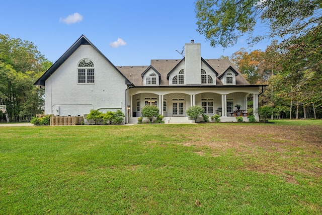 rear view of property with a lawn and a porch