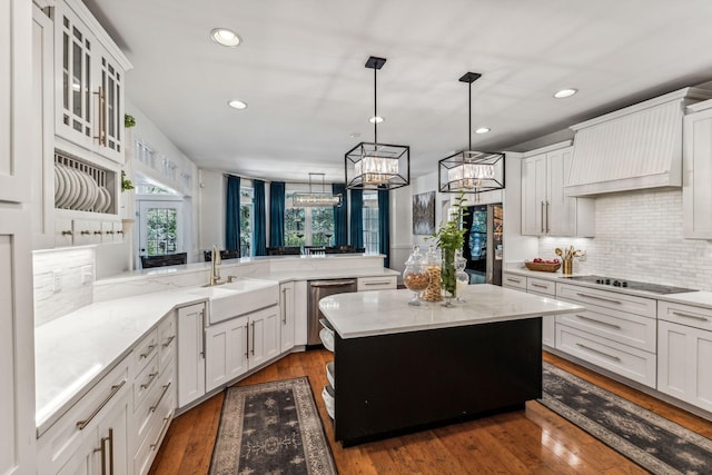 kitchen with sink, dark hardwood / wood-style flooring, kitchen peninsula, a kitchen island, and appliances with stainless steel finishes