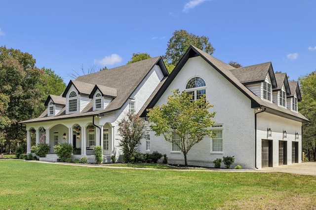 view of front facade with a front yard, a garage, and covered porch