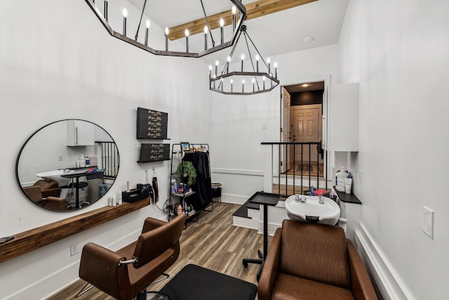 dining area with wood-type flooring, a towering ceiling, and an inviting chandelier