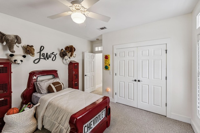 bedroom with ceiling fan, multiple windows, light carpet, and a closet