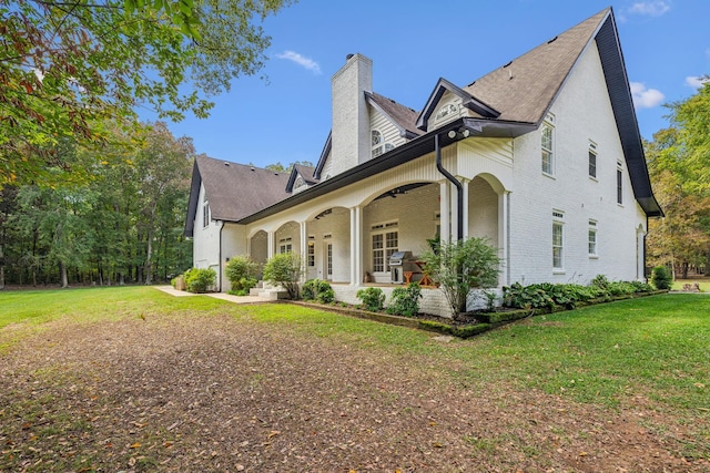 view of side of property with covered porch and a yard