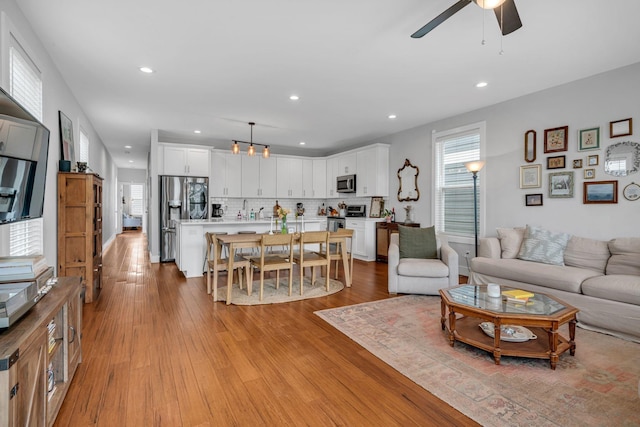 living room featuring ceiling fan and light wood-type flooring