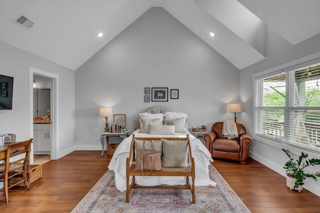 bedroom with wood-type flooring, connected bathroom, and vaulted ceiling