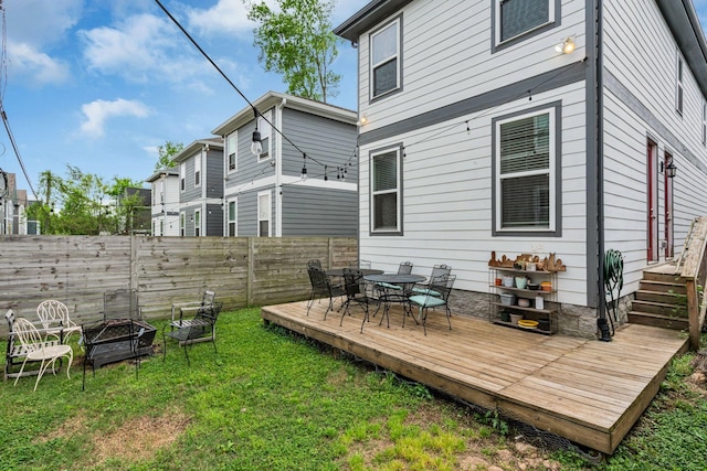 rear view of house featuring a fire pit, a yard, and a wooden deck