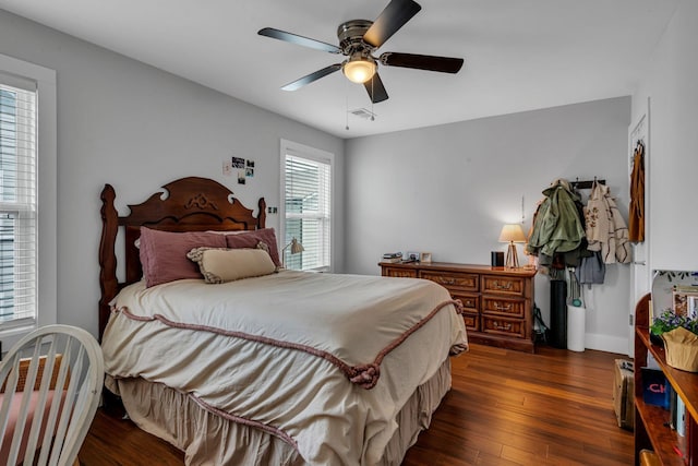 bedroom with multiple windows, ceiling fan, and dark hardwood / wood-style flooring