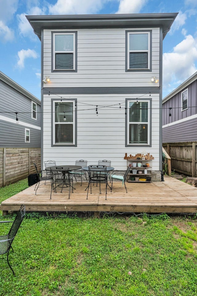 back of house with a lawn and a wooden deck