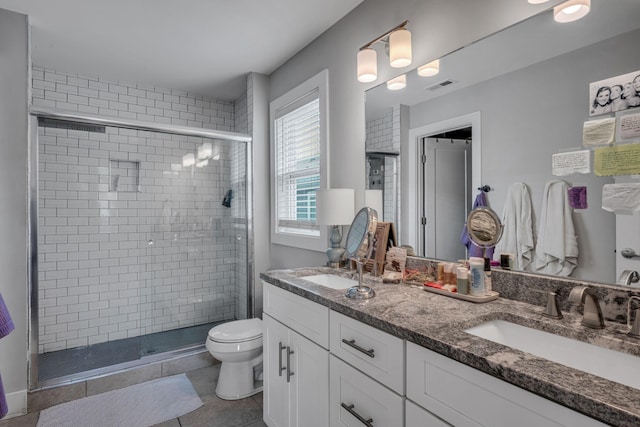 bathroom featuring tile patterned floors, vanity, toilet, and a shower with door