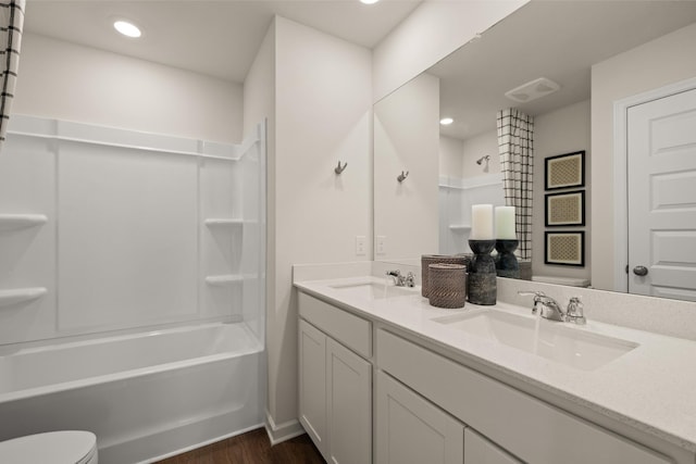 full bathroom with bathtub / shower combination, vanity, hardwood / wood-style flooring, and toilet