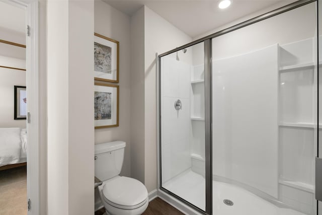 bathroom with hardwood / wood-style flooring, toilet, and walk in shower