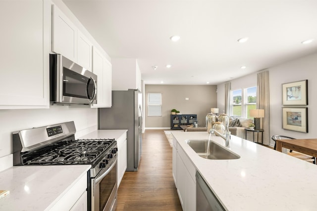 kitchen featuring white cabinetry, light stone counters, sink, and appliances with stainless steel finishes