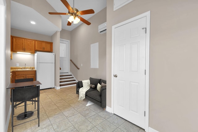 kitchen with ceiling fan, sink, a wall mounted air conditioner, white fridge, and lofted ceiling