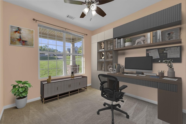 carpeted home office featuring ceiling fan