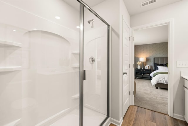 bathroom featuring hardwood / wood-style flooring, vanity, and a shower with door