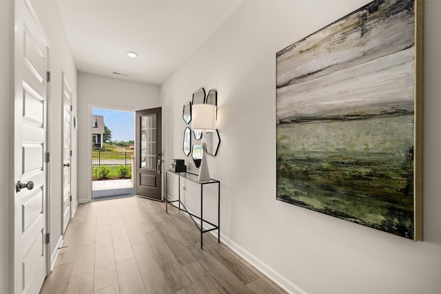 corridor with light hardwood / wood-style floors