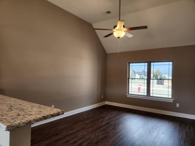 unfurnished living room with ceiling fan, vaulted ceiling, and dark hardwood / wood-style floors