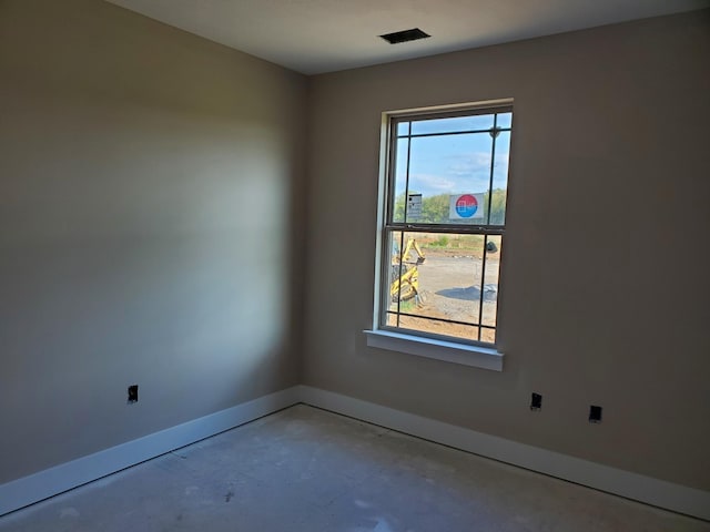 empty room with concrete flooring and a wealth of natural light