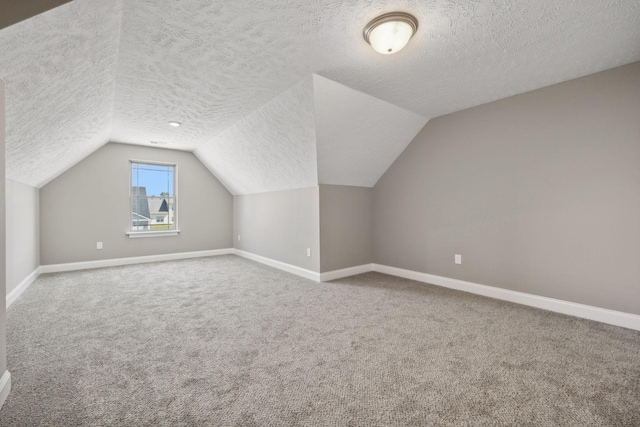 bonus room featuring a textured ceiling, carpet flooring, and lofted ceiling