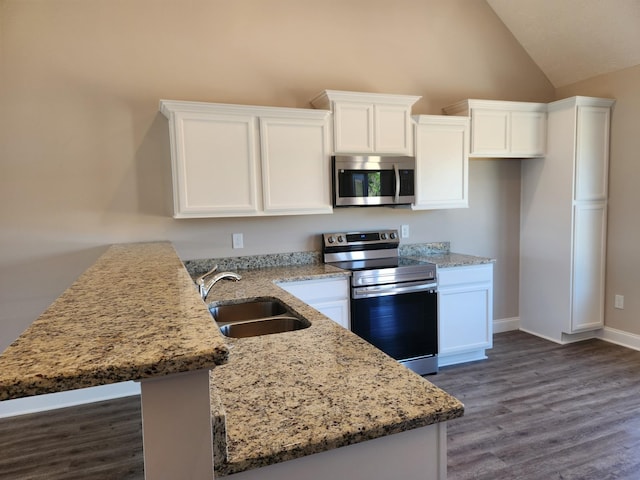 kitchen featuring vaulted ceiling, sink, appliances with stainless steel finishes, white cabinets, and light stone counters