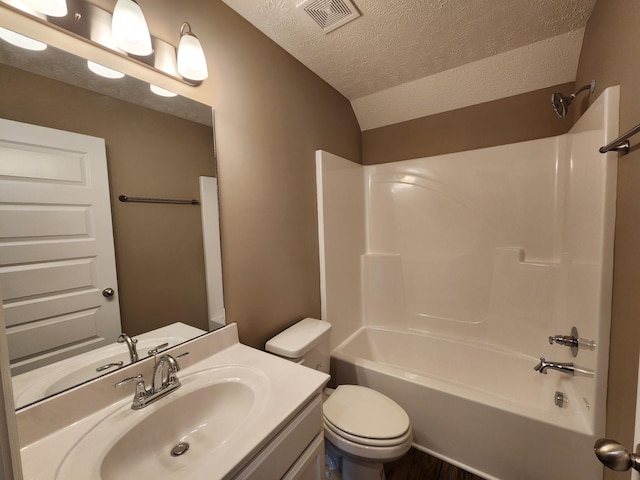 full bathroom featuring lofted ceiling, vanity, toilet, shower / washtub combination, and a textured ceiling