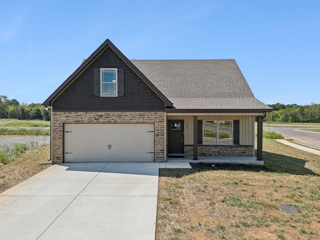 craftsman-style house featuring covered porch, a front yard, and a garage