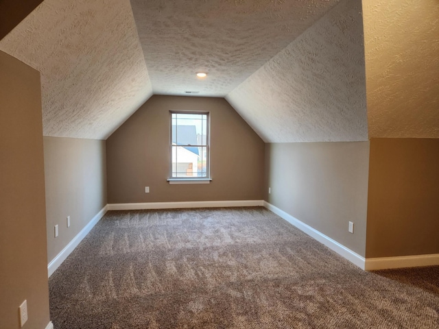 bonus room with lofted ceiling, a textured ceiling, and carpet flooring