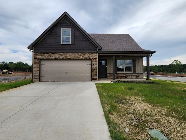 view of front of home featuring a front yard, a porch, and a garage