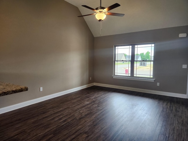 spare room with ceiling fan, vaulted ceiling, and dark wood-type flooring