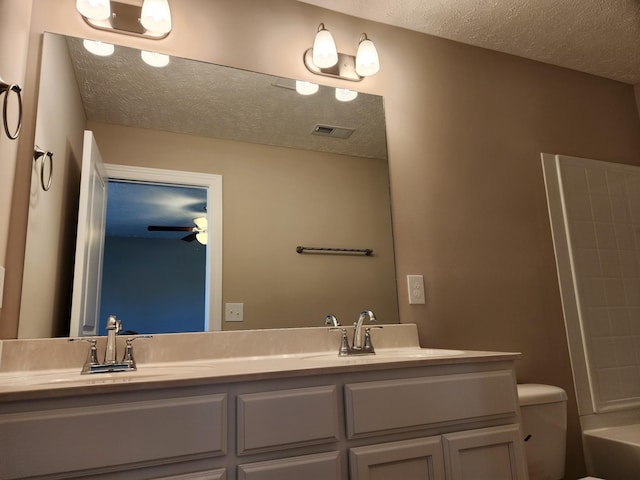 full bathroom featuring ceiling fan, vanity, toilet, a textured ceiling, and bathtub / shower combination