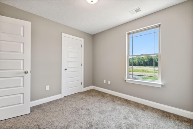 unfurnished bedroom with light colored carpet and a closet