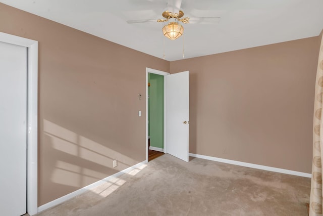 carpeted spare room featuring ceiling fan