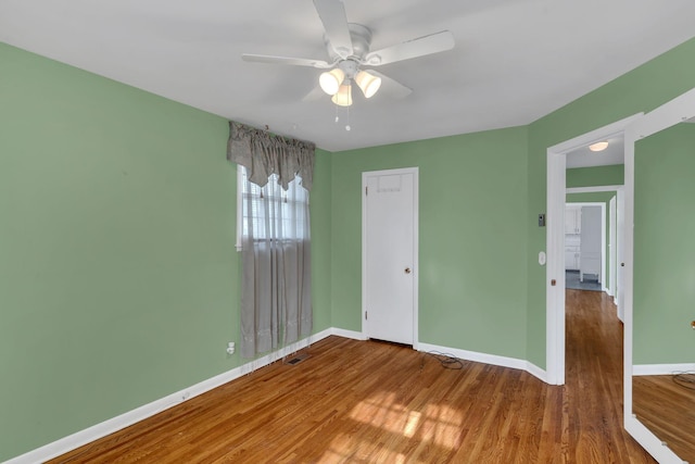 unfurnished bedroom featuring ceiling fan, wood-type flooring, and a closet