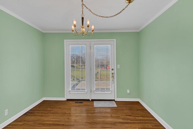 unfurnished room with a chandelier, hardwood / wood-style flooring, and crown molding