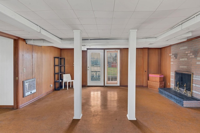 basement with heating unit, wooden walls, and a fireplace