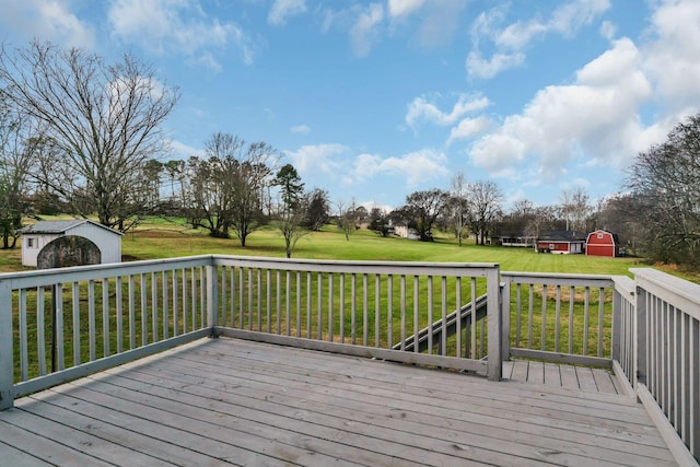 wooden deck with a shed and a lawn