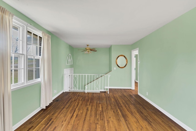 unfurnished room featuring ceiling fan and dark wood-type flooring