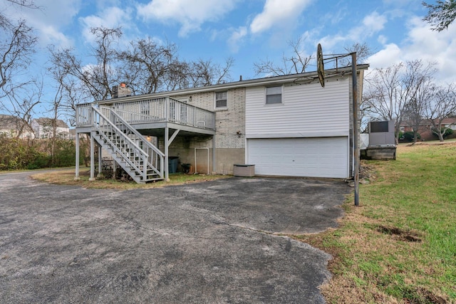 rear view of property with a wooden deck and a garage