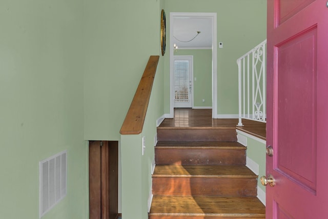 stairway with ornamental molding and an inviting chandelier