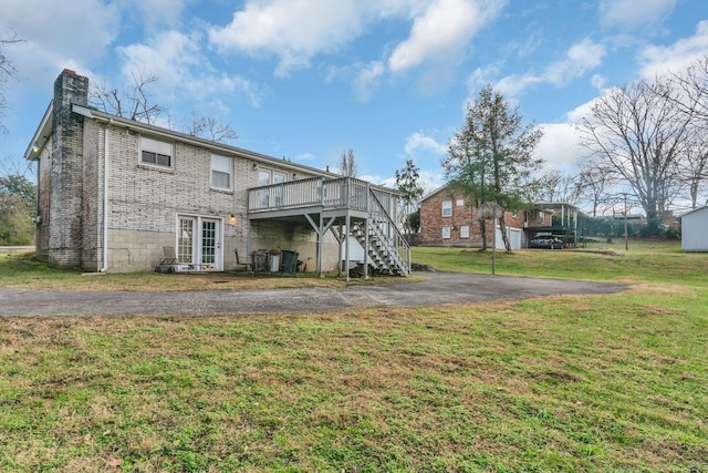 rear view of property with a yard and a deck