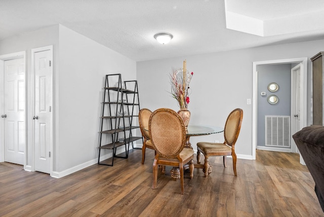 dining space featuring dark hardwood / wood-style flooring and a textured ceiling