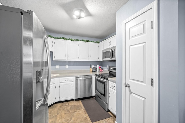 kitchen with white cabinets, a textured ceiling, and appliances with stainless steel finishes