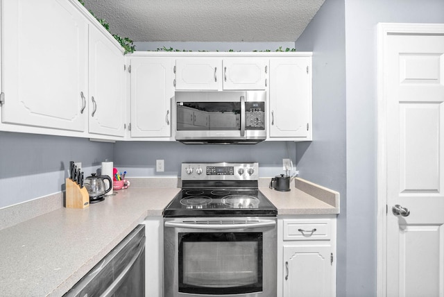 kitchen featuring a textured ceiling, white cabinetry, and stainless steel appliances