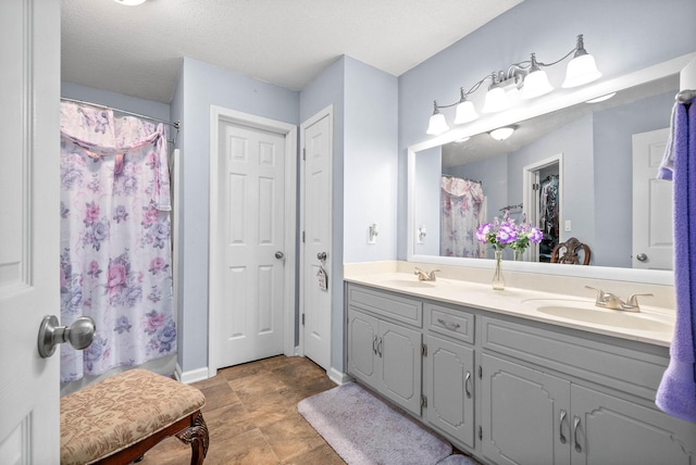 bathroom featuring a textured ceiling, vanity, and a shower with curtain