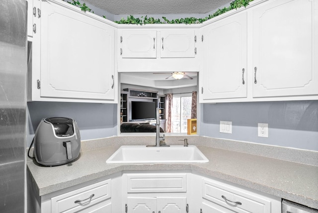 kitchen with white cabinetry, ceiling fan, and sink