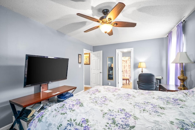 bedroom featuring a textured ceiling, ensuite bath, and ceiling fan