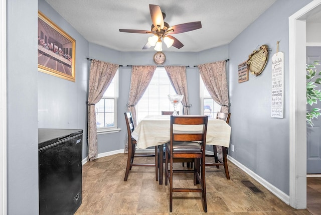 dining room featuring ceiling fan and a textured ceiling