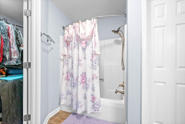 bathroom with a textured ceiling and shower / tub combo with curtain