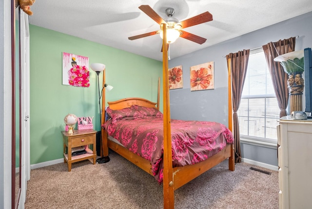 carpeted bedroom with ceiling fan and a textured ceiling