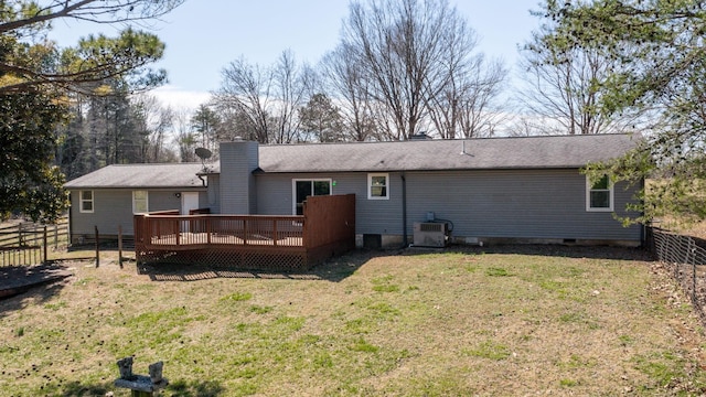 back of property with a chimney, a lawn, crawl space, fence, and a deck