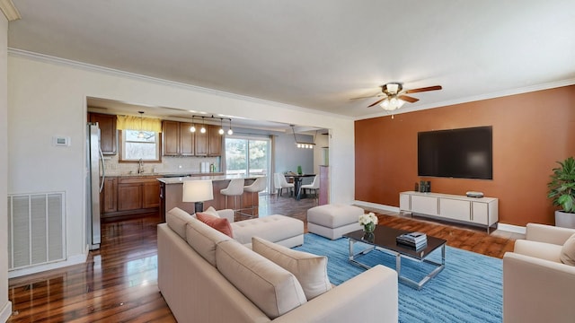 living room with ornamental molding, dark wood-style flooring, and visible vents